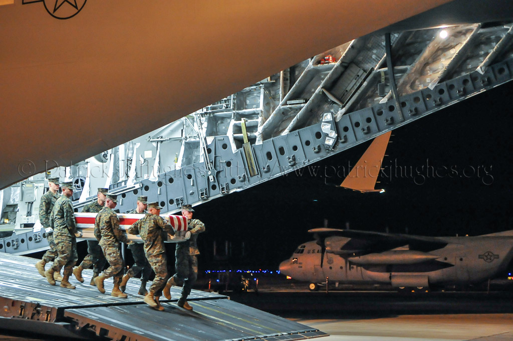 Marine carry team carries transfer case of Lance Corporal Jacob Alexander Meinert from back of C-17