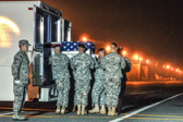 Army carry team moves the transfer case with the believed to be remains of Spc. Michael B. Cook Jr., into mortuary transfer vehicle.