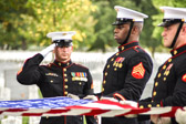 Gunny Sgt Nicholas J. Brundige salutes as flag folding ceremony begins