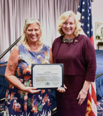 GSM National President Sue Pollard holding certificate of recognition from the Pro Tempore Mayor of the City of Irvin California Lynn Schott.