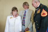 New American Gold Star Mother National President Jo Ann Maitland is pinned by her husband Frank as Gunny Louis Slagle looks on.