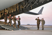 Marine carry team carries transfer case of Lance Corporal Mark David Juarez from back of C-17