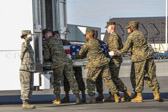 Carry team moves transfer case into the mortuary transfer vehicle