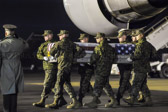 Marine carry team carries transfer case of Master Sgt. Travis W. Riddick  to the mortuary transfer vehicle