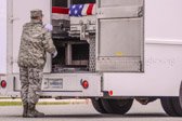Transfer vehicle guide Senior Airman Zachary S. Szczypinski closes the doors to transfer vehicle