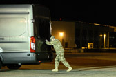 Transfer vehicle guide Senior Airman Electa Hazenstab closes the doors to transfer vehicle.