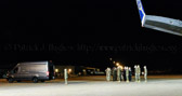 Carry team follows (by walking) transfer vehicle, with the transfer vehicle guide walking behind the carry team.  Dignified transfer officer and senior ranking officer follow (walking) behind the transfer vehicle guide, ending the dignified transfer