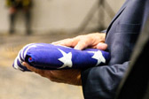 Our Country's flag is presented to Becky Christmas, then placed onto the table
