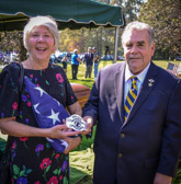 Kenneth Schweitzer, President of VVA 436, presents the ex-wife of Major Louis Fulda Guillermin with one of their chapters “Honor Guard” patches.