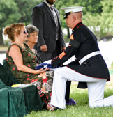 Kimb Brown surviving niece of PFC Robert Junior Carter presented with the flag of a grateful nation.