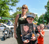 Christian Jacobs holing photograph of his Father Sgt. Christopher James Jacobs who is buried in Arlington National Cemetery Section 60.