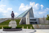 Before there was the Iwo Jima Statue, there was “Iron Mike.” Erected in 1924 to Marines who fought in World War I, “Iron Mike” pre-dates the depot’s Iwo Jima Statue by 28 years. The statue once stood in a prominent location in the center of the base and was the symbol of Parris Island. <br />Though its origins are obscure, it seems that money for a monument to Parris Island Marines who died in World War I was originated “by officers and men in small amounts during the war, for the purpose of erecting a memorial to the marines who were trained at Parris Island and lost their lives during the world war.” While fund raising continued, solicitations went out for sculptors to submit designs. <br />The driving force behind the monument was Brig. Gen. Eli Cole, who had commanded Parris Island in 1918 before being sent to France. He returned to Parris Island in September 1919, and during his tenure, the project was pushed forward. Cole was in touch with the National Academy of Design in the city of New York and had the backing of Marine Corps war veterans, including the highly decorated Lt. Col. Frank Evans.