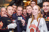 Marines holding a set of four new postage stamps honoring the Marine Corps