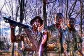 The statue and the Wall appear to interact with each other, with the soldiers looking on in solemn tribute at the names of their fallen comrades.